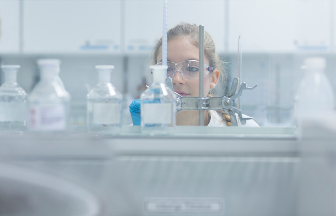 Medical researcher behind test tubes in a lab.